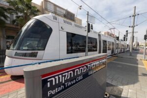 תחנת הרכבת הקלה בפתח תקווה, המראה את רכבת הקו האדום ואת השילוט של התחנה המרכזית.
