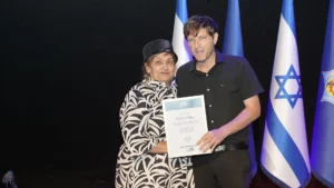 אליה קוזולה, מקבל אות יקיר העיר 2025, עם ראש העיר רמי גרינברג והתעודה.