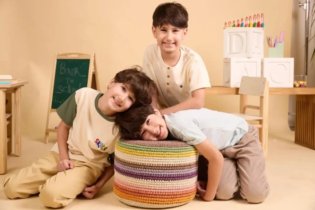 שלושה בנים, יהלי, רביד וקורן, בני 10, מחייכים על סט צילומים עבור קמפיין שניידר-Factory 54 להעלאת מודעות למחלת מויה מויה.