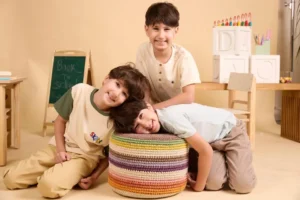 שלושה בנים, יהלי, רביד וקורן, בני 10, מחייכים על סט צילומים עבור קמפיין שניידר-Factory 54 להעלאת מודעות למחלת מויה מויה.