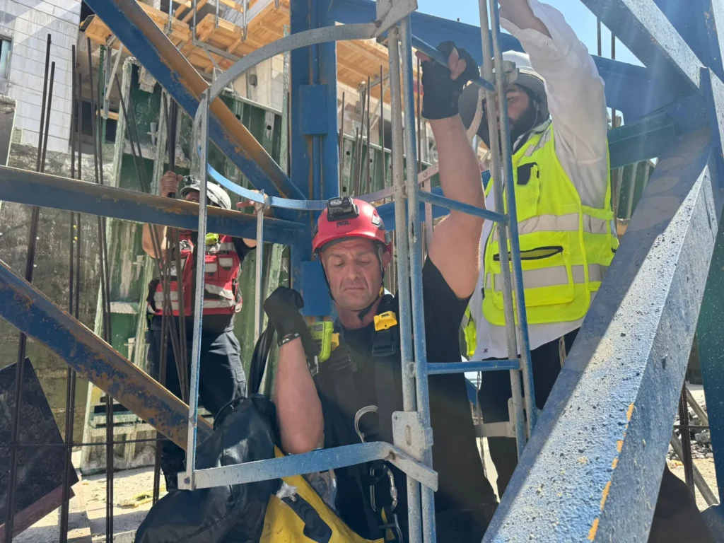 איש כבאות והצלה בתוך עגורן מחלץ אדם שלא חש בטוב