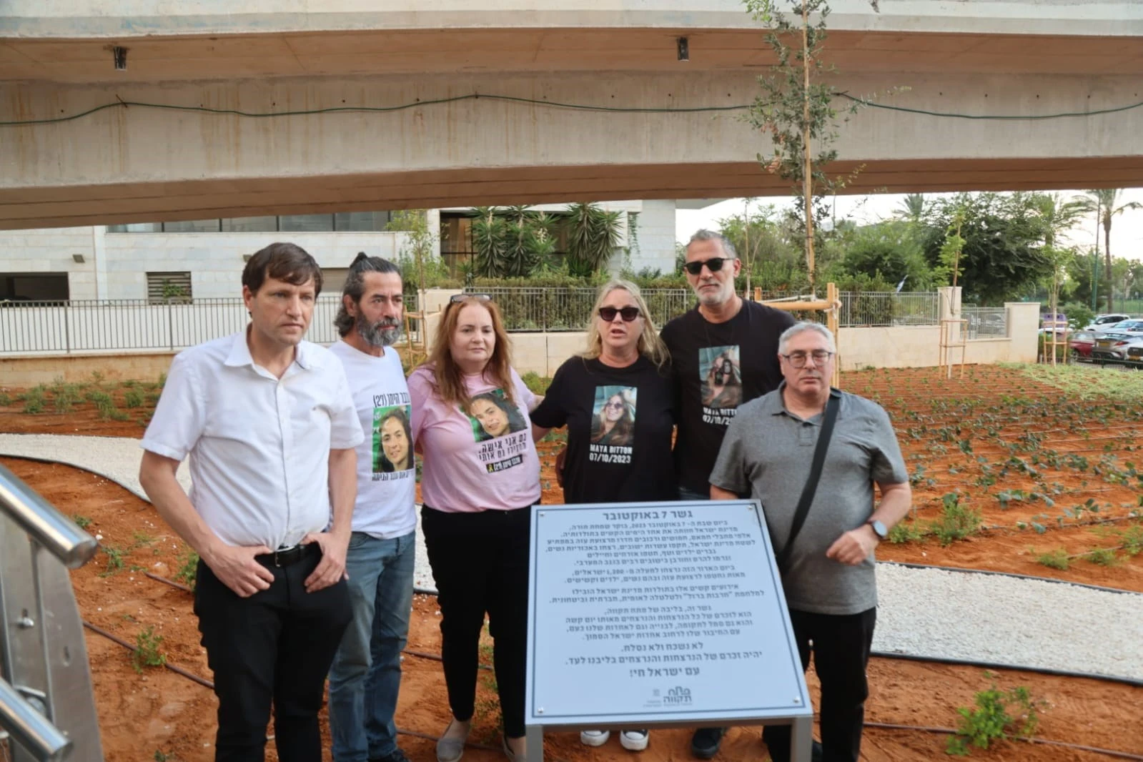 ראש העיר פתח תקווה רמי גרינברג ונציגי משפחות עומדים ליד לוח זיכרון בטקס חנוכת הגשר