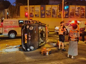 זירת תאונת דרכים בפתח תקווה עם רכב הפוך, אמבולנס ואנשי איחוד הצלה ברחוב אבי הורן.