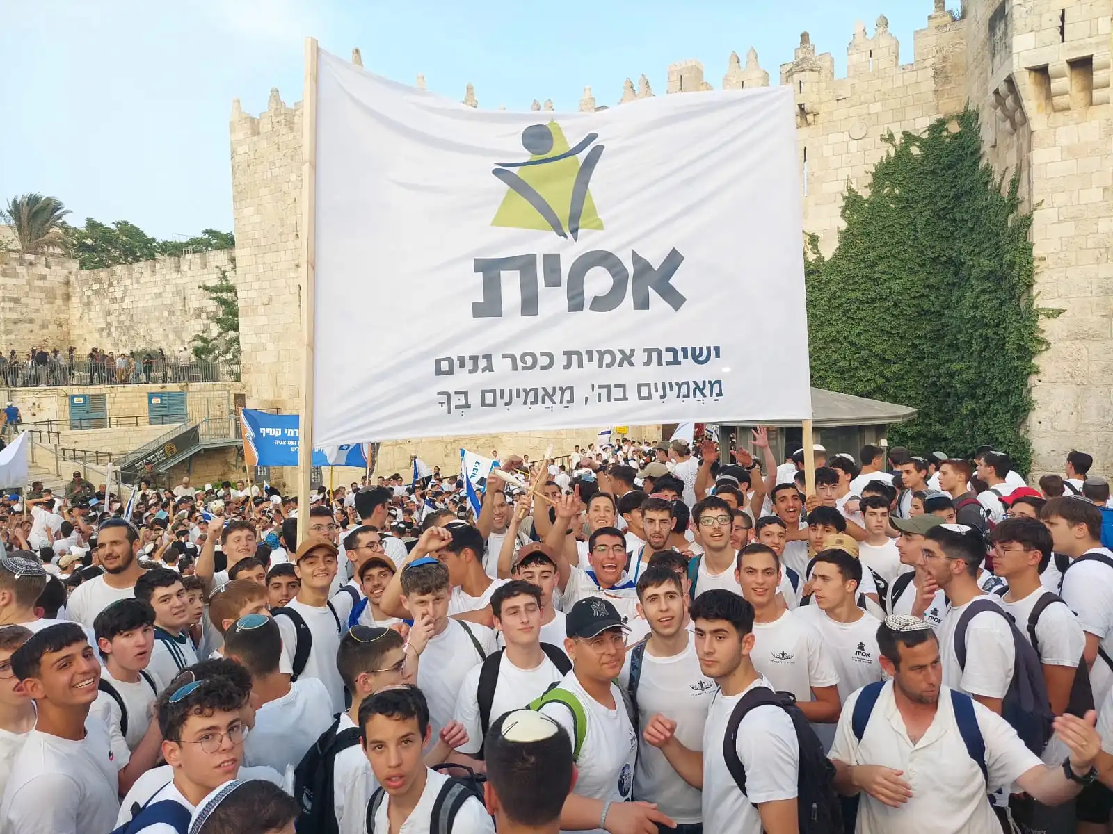 תלמידי ישיבת אמית כפר גנים פתח תקווה מניפים שלט גדול של הישיבה ברחבת הכותל